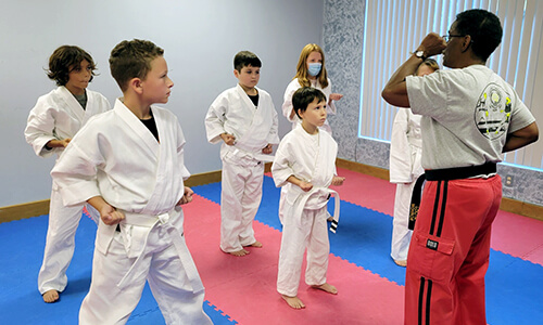 Young Rouleau-Holley's Martial Arts students watch as Master Monroe demonstrates a technique